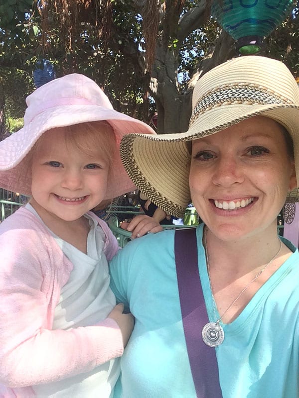 A mom and little girl in sunhats.