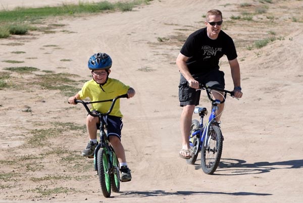 A Dad and son riding bikes together. 