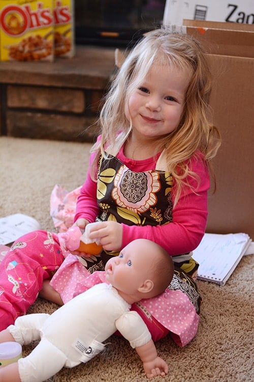 A little girl playing with a doll.