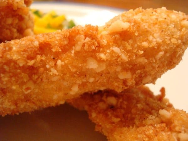 Two fried chicken strips on a white plate.