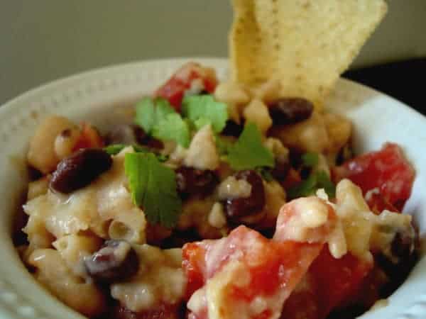 Bowl of black and white bean dip with chip.