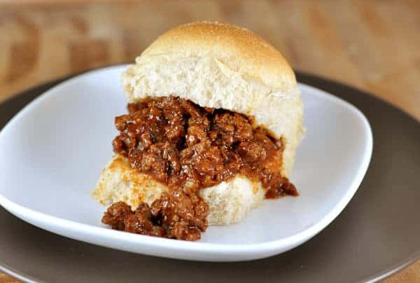 sloppy joe on a roll on a white plate