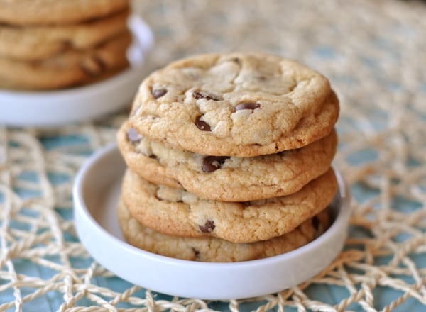 four chocolate chip cookies stacked in a white bowl