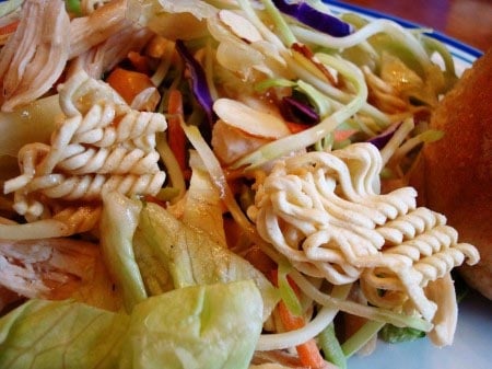 Asian chicken salad on a white plate.