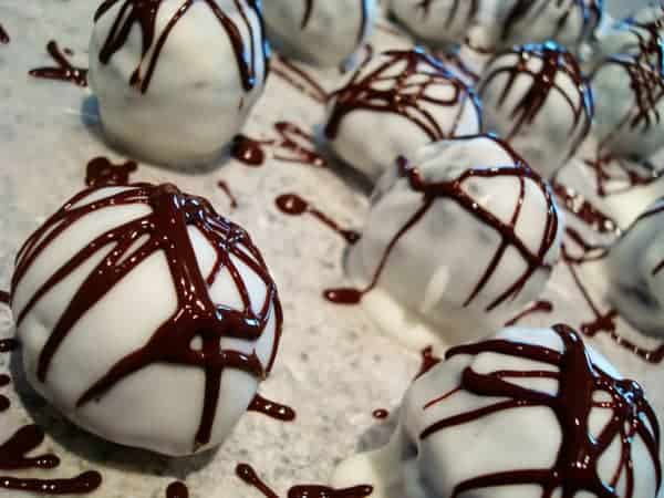 White chocolate dipped truffles with chocolate drizzle.