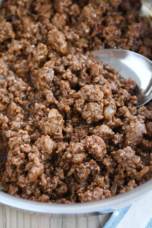 Sloppy joe meat in stainless pan with serving spoon.