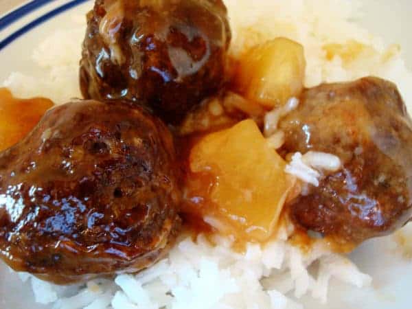 Meatballs and pineapple chunks on a bed of rice.