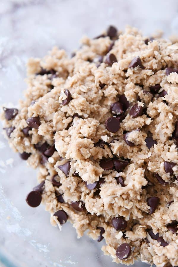 oatmeal chocolate chip coconut cookie batter in glass bowl