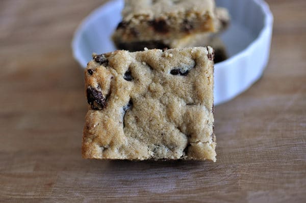 cut chocolate chip bar laying next to white bowl