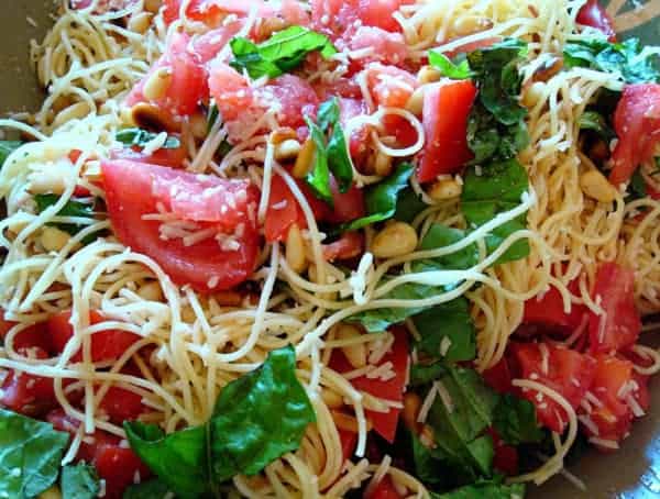 Spaghetti noodles with spinach and tomato.