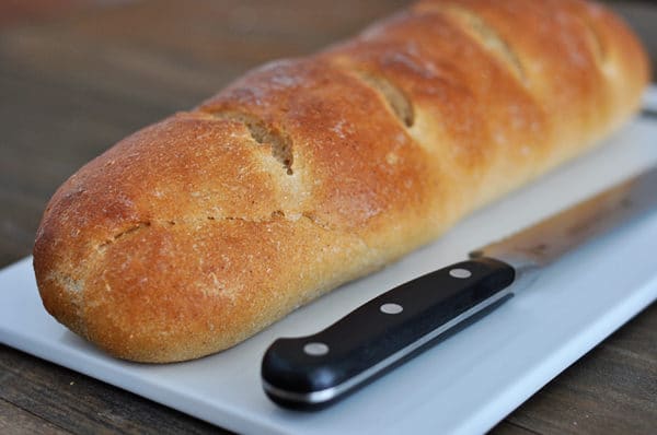 loaf of french bread on a white cutting board