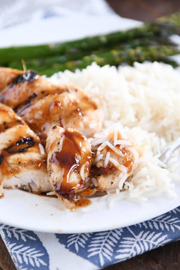 A couple bites cut off of the sticky coconut chicken with coconut rice.