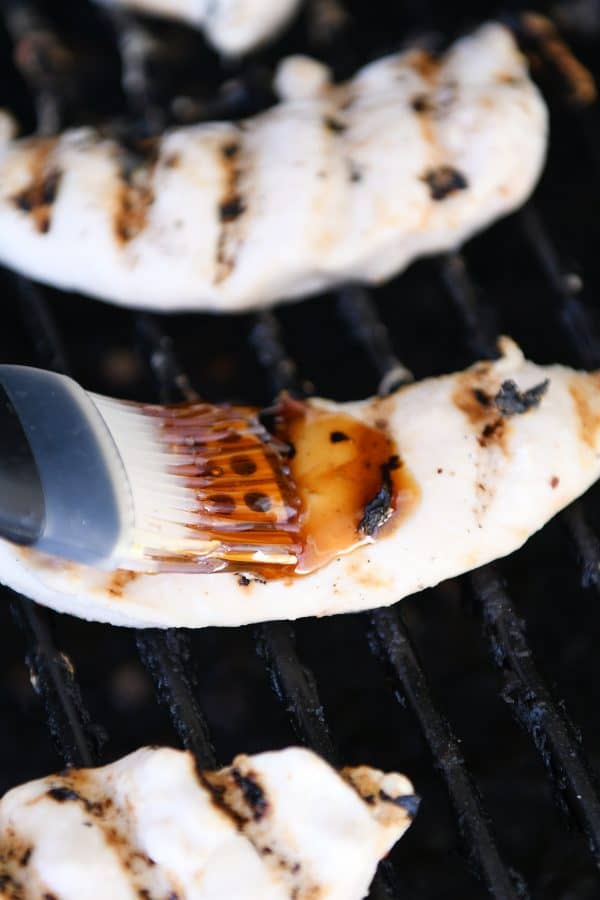 Brushing glaze on grilled coconut chicken.
