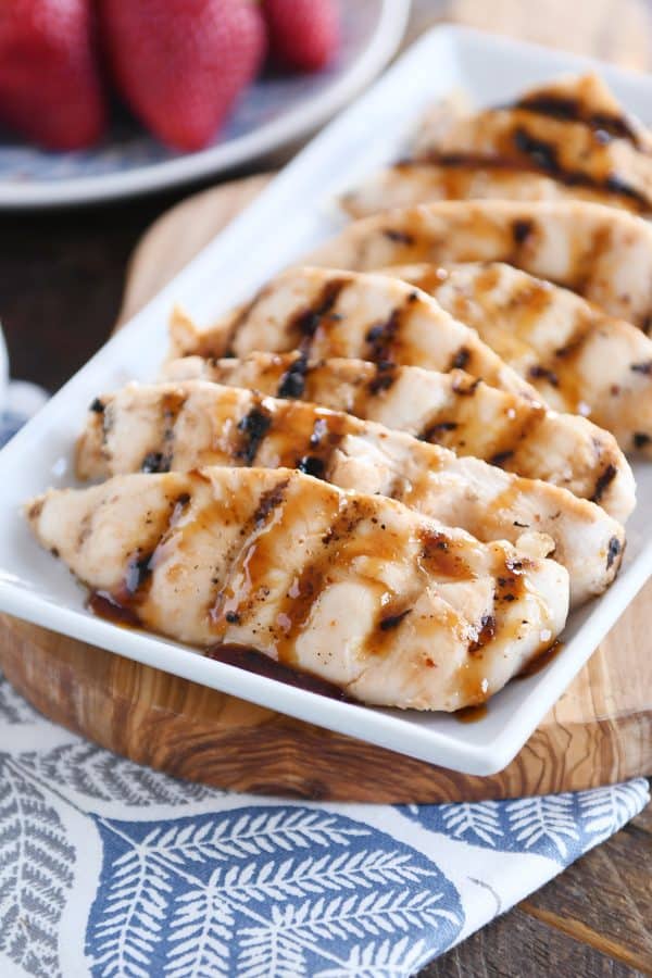 Pieces of sticky coconut chicken on white platter.