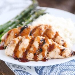 sticky coconut chicken on white plate with coconut rice and asparagus