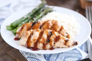 sticky coconut chicken on white plate with coconut rice and asparagus