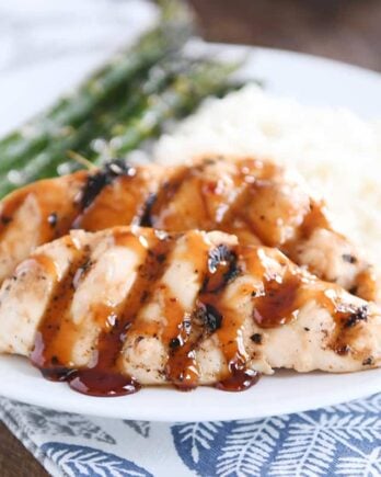 sticky coconut chicken on white plate with coconut rice and asparagus