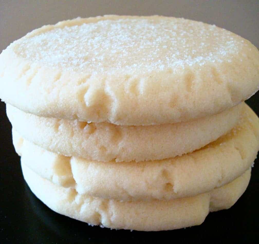 Stack of sugar cookies on a black plate.