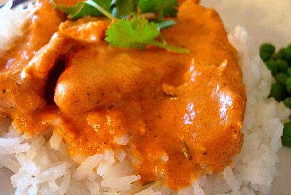 Chicken tikka and orange sauce on white rice.