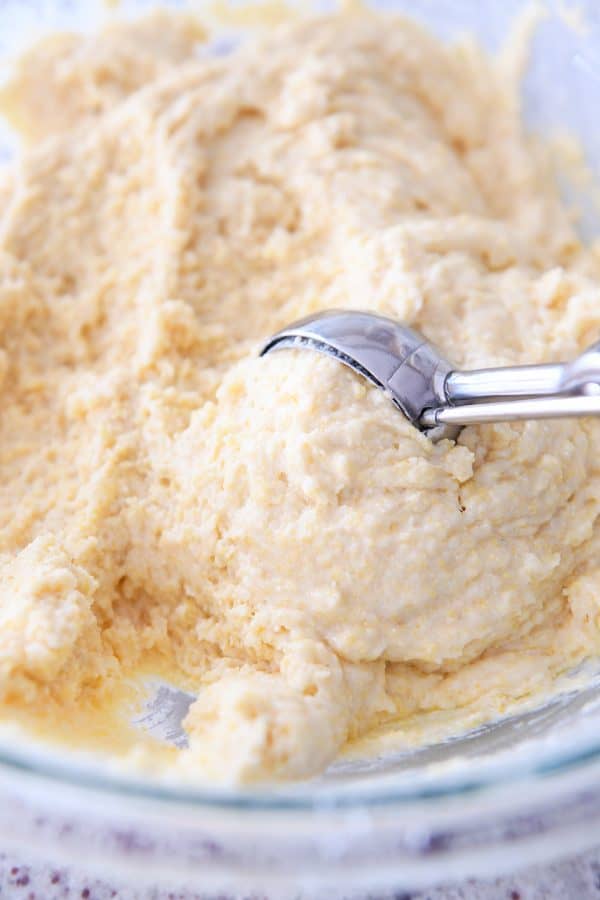 Scooping cornbread muffin batter with cookie scoop.