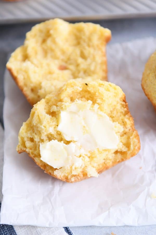 Cornbread muffin split in half with butter.