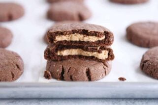 stack of chocolate peanut butter stuffed cookies with top cookie broken in half