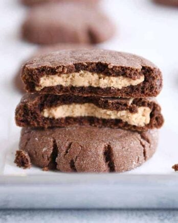 stack of chocolate peanut butter stuffed cookies with top cookie broken in half