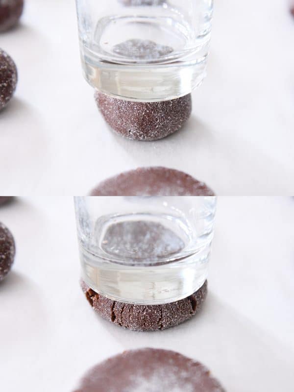 Pressing chocolate peanut butter stuffed cookies with glass dipped in sugar.