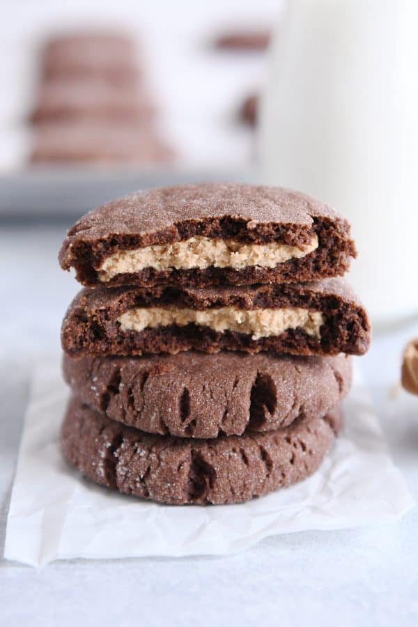 stack of chocolate peanut butter stuffed cookies with top cookie broken in half