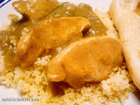 Chicken slices with green curry sauce on white rice.