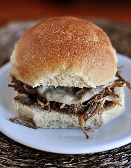 Shredded beef sandwich on a white plate.