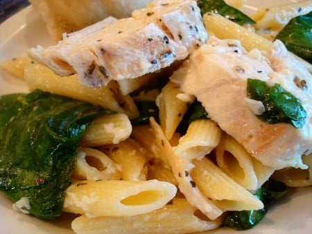 Pasta dish with spinach and chicken slices.