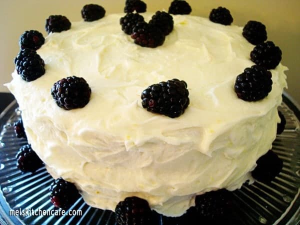 Frosted cake with blackberries around the side and top.