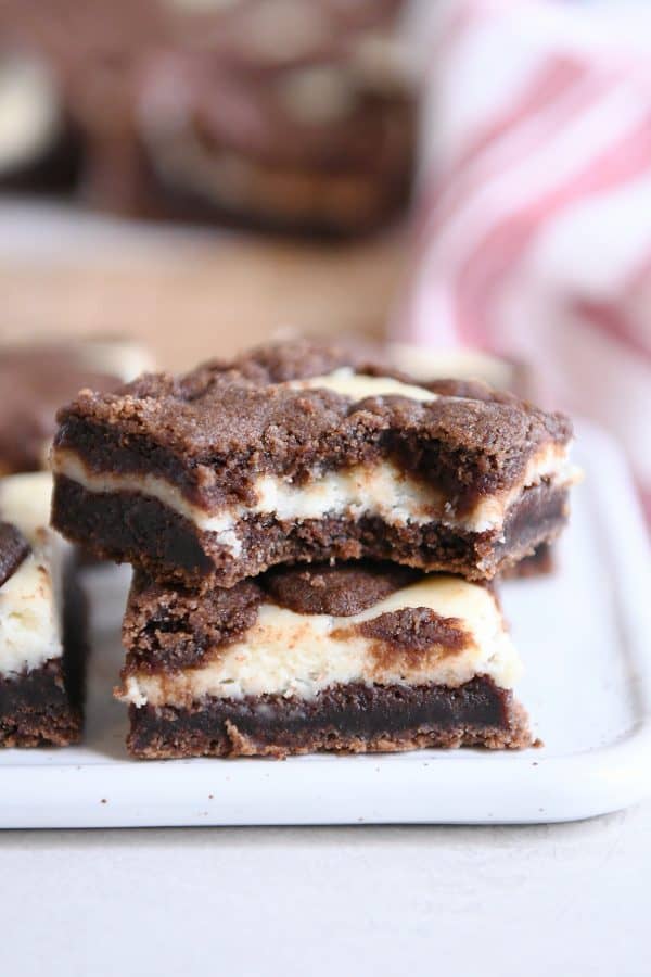 Black and white cheesecake brownies stacked on each other.