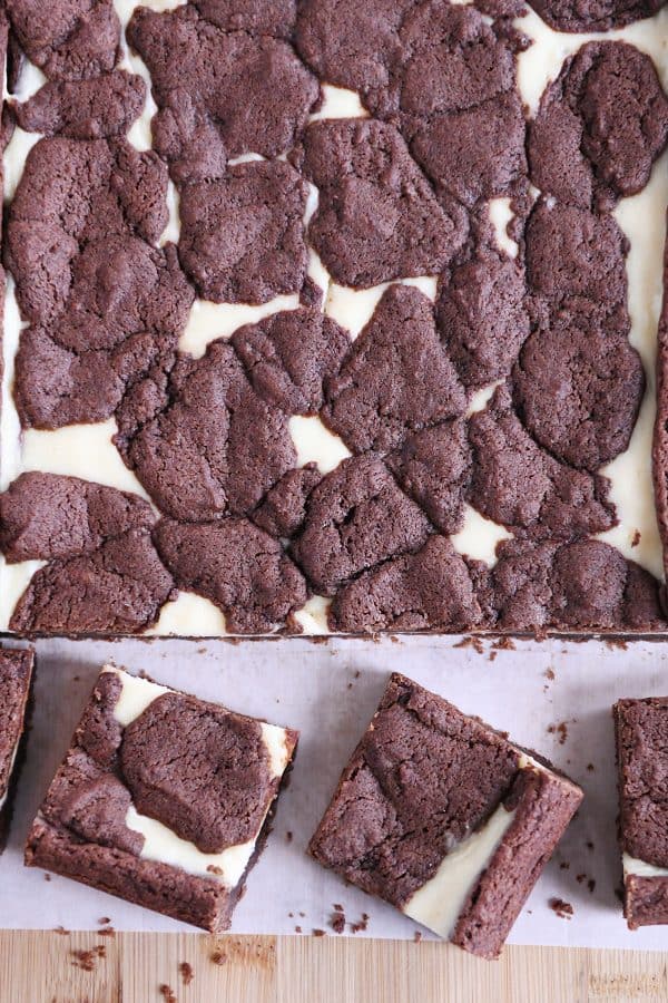 Pan of baked and cut black and white cheesecake brownies.