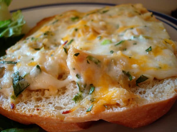 Piece of bread with melted cheese on top.