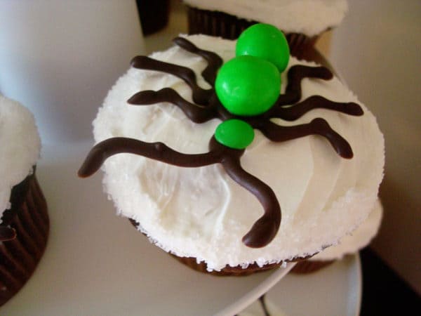 frosted cupcake with a chocolate and m&m ant on top