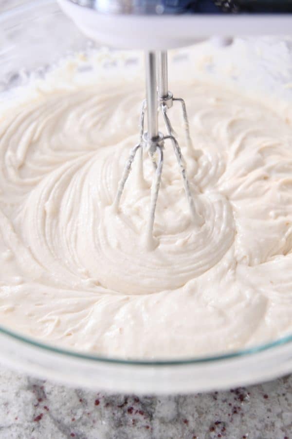 Mixing chocolate chip cake batter with handheld mixer.