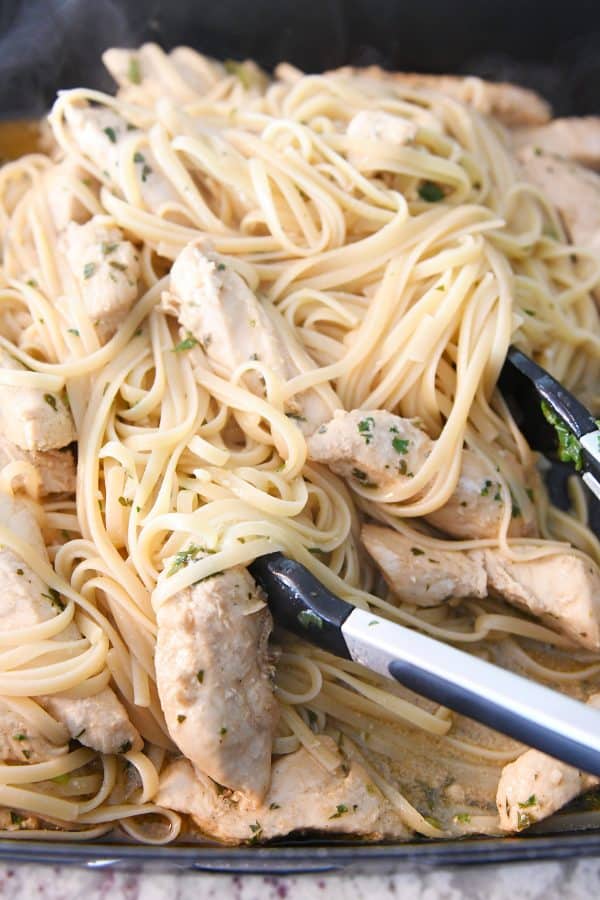 Tossing linguine with cooked chicken.