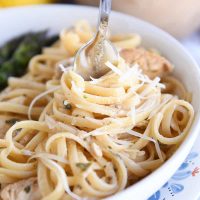 twisting pasta in white dish around fork