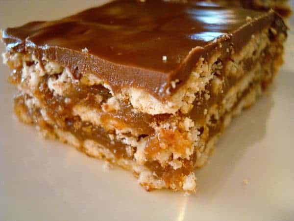 Layered caramel crunch bar on a white plate.