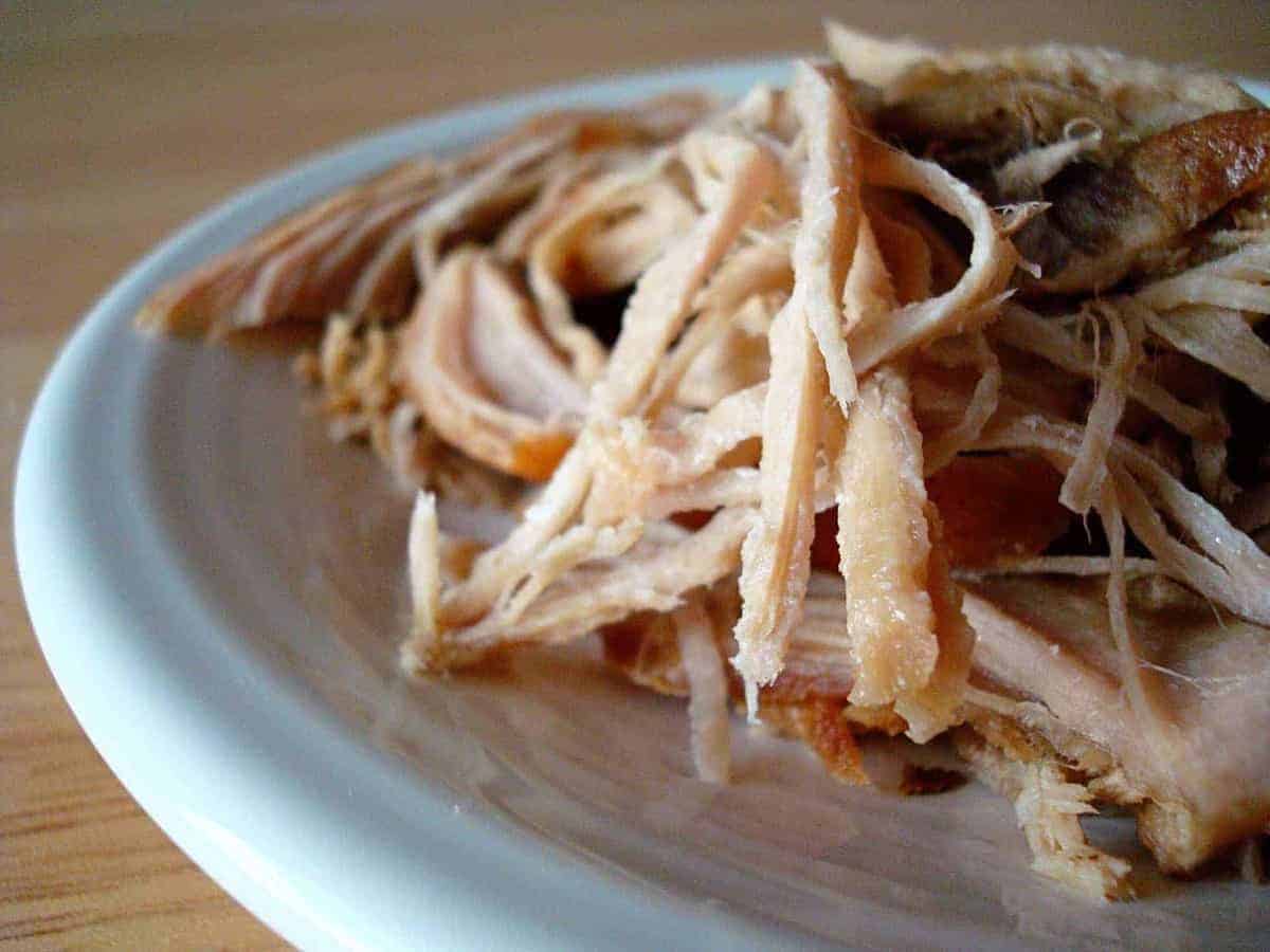 Shredded pork on a white plate.