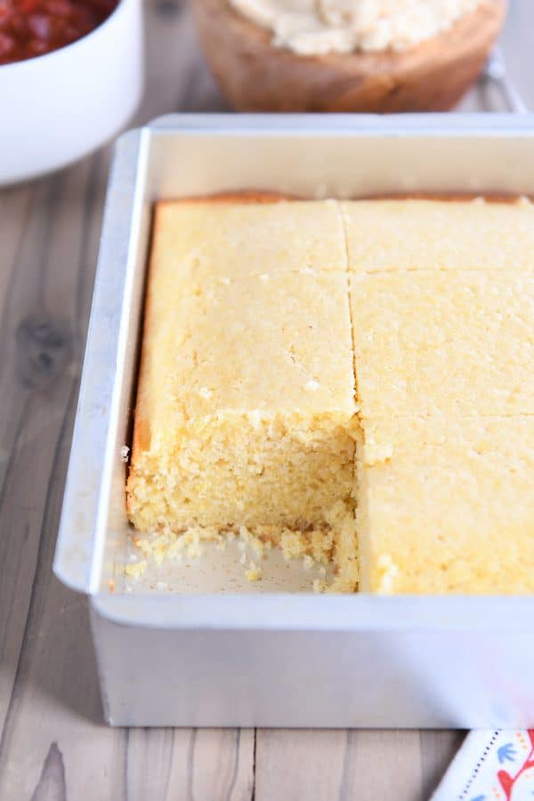 Pan of cornbread with piece cut out.