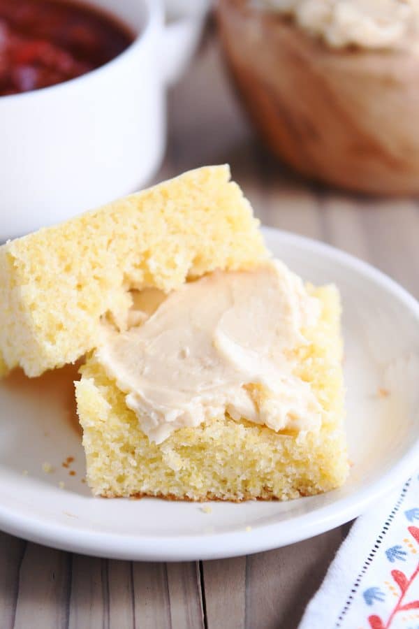 Piece of cornbread sliced in half with fluffy honey butter.