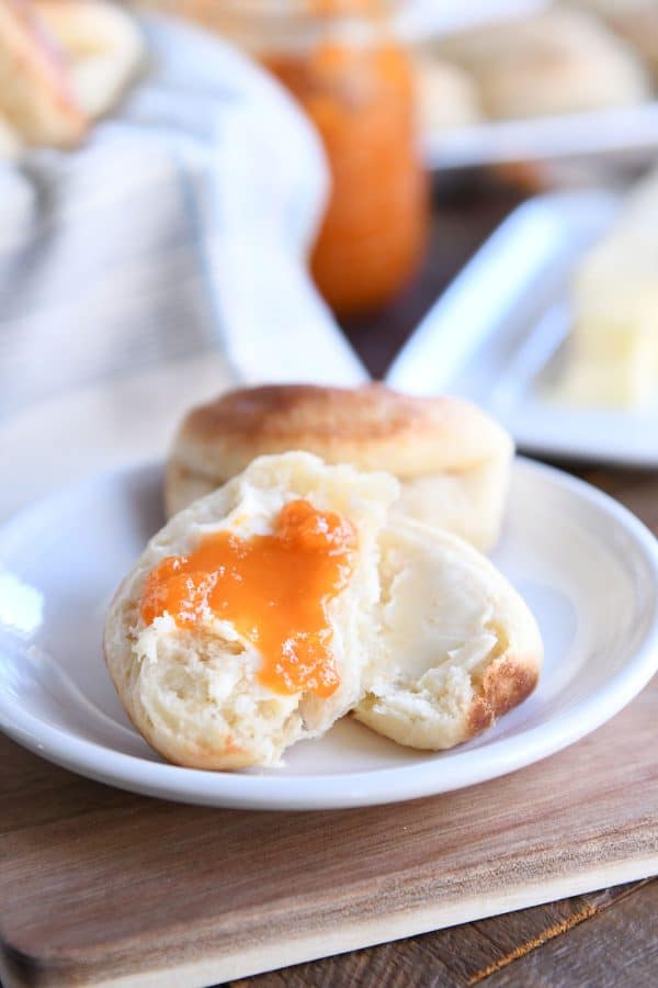 Fluffy Parker house roll in half with butter and apricot jam. 