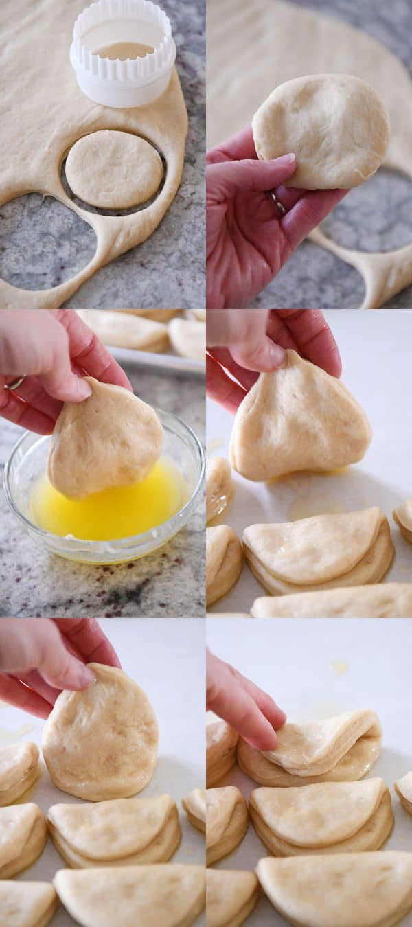 Dipping Parker house rolls in butter and putting them on the sheet pan.