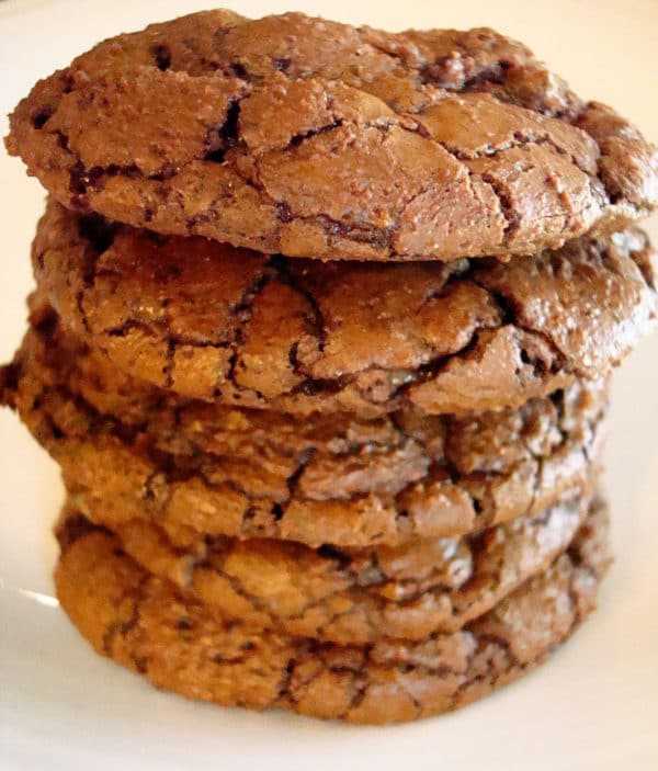 Stack of chocolate cookies on a white plate.