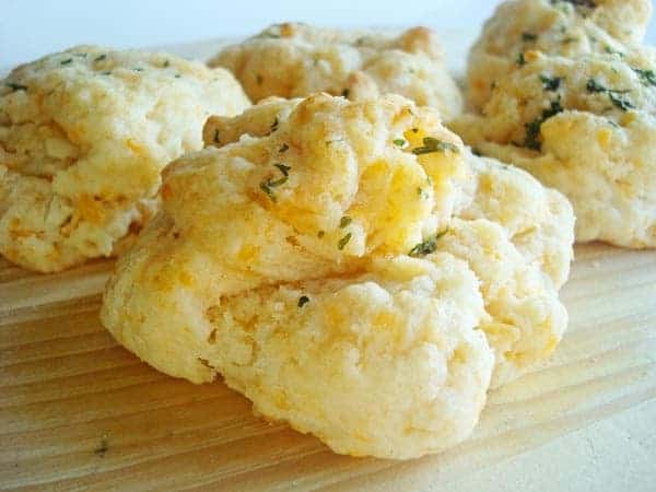 Cheddar herb biscuits on a wooden board.