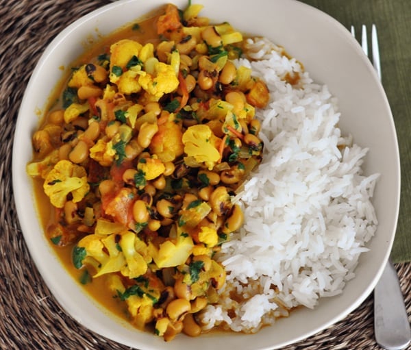 Top view of curry and white rice in a white bowl.