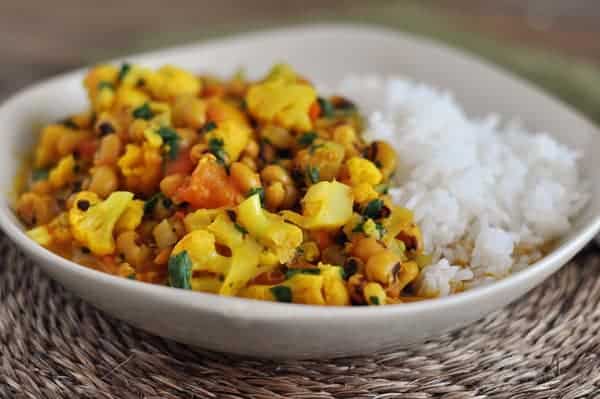 Curry and white rice in a white bowl.